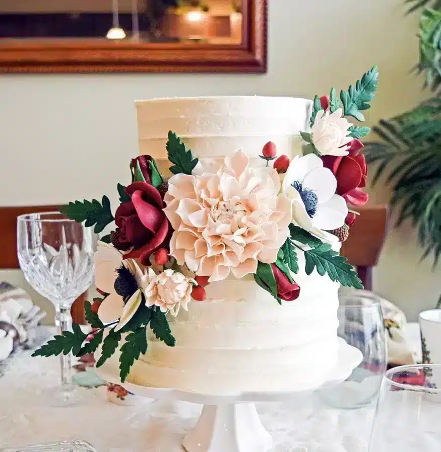 Sugar Flower Cascade with One large flower, 4 medium flowers, 2 small flowers, and assorted leaves and berries and  rose buds