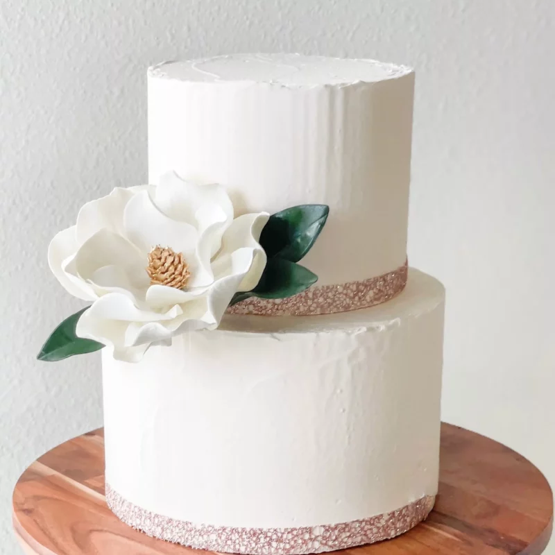 white modern magnolia styled on a two tier cake