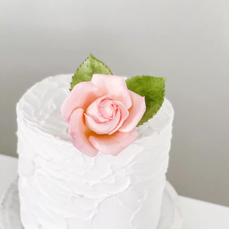 small blush rose sugar flower cake topper sitting on a 6 inch one tier cake