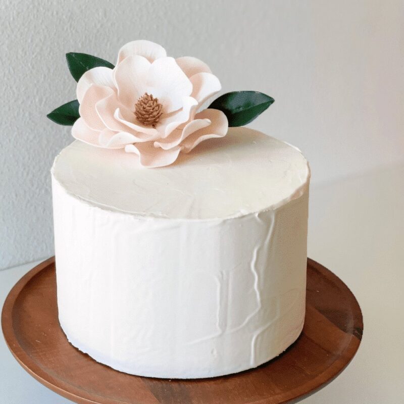 blush magnolia sugar flower on buttercream cake