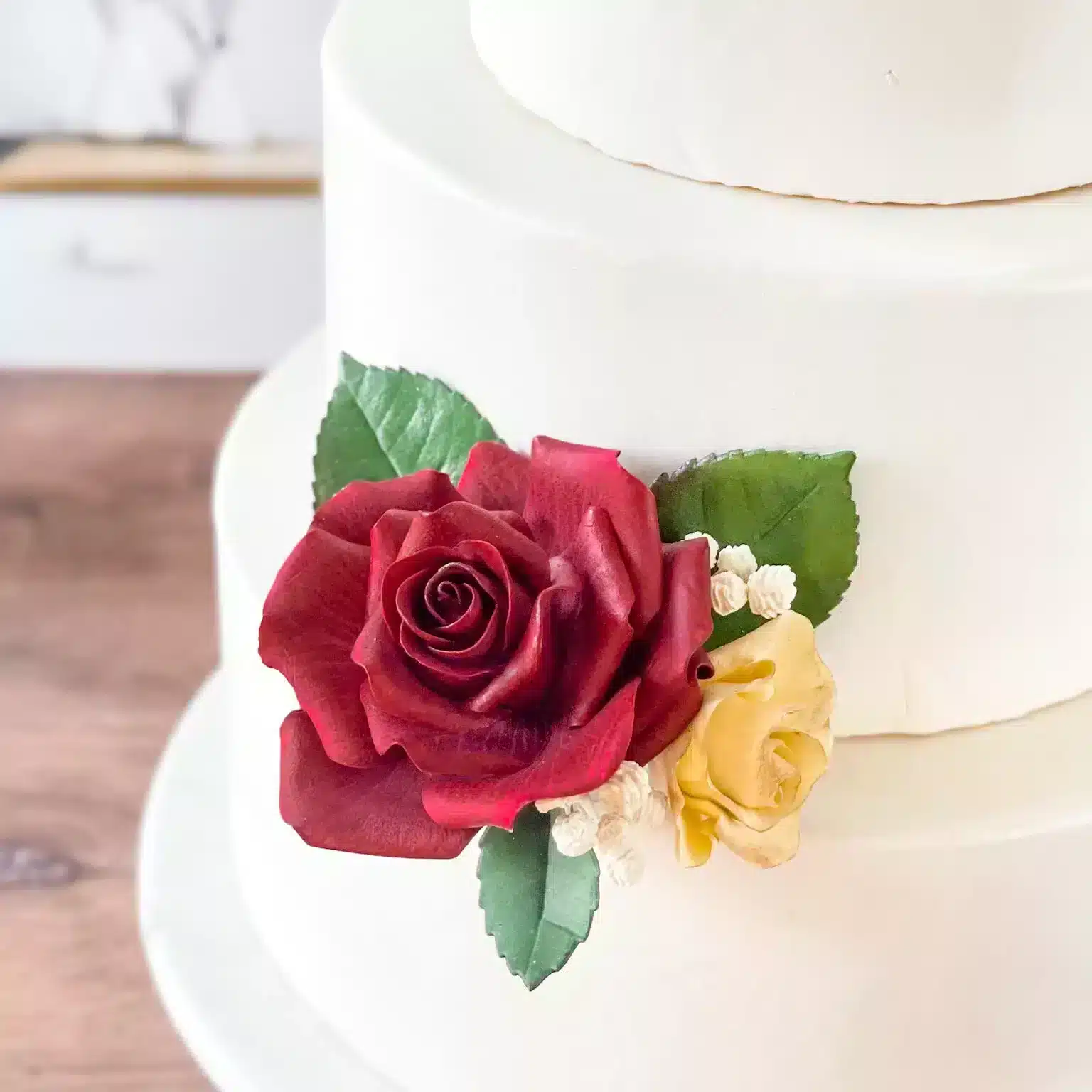 three tier cake with red rose sugar flower close up