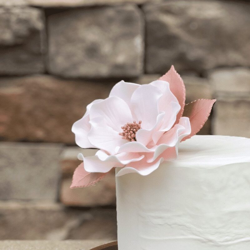 blush and rose gold open rose sugar flower with Gumpaste leaves