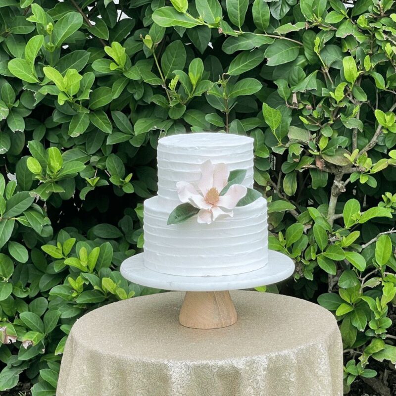 pink saucer magnolia sugar flower on a buttercream wedding cake