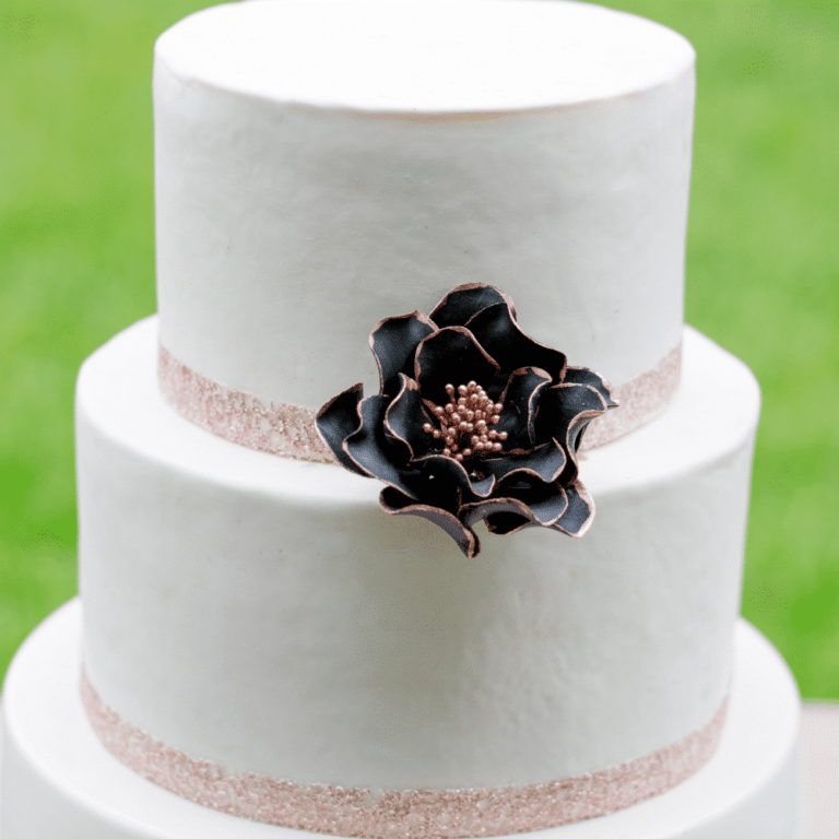 Small black rose gold edging open rose sugar flower on a two tier white fondant wedding cake