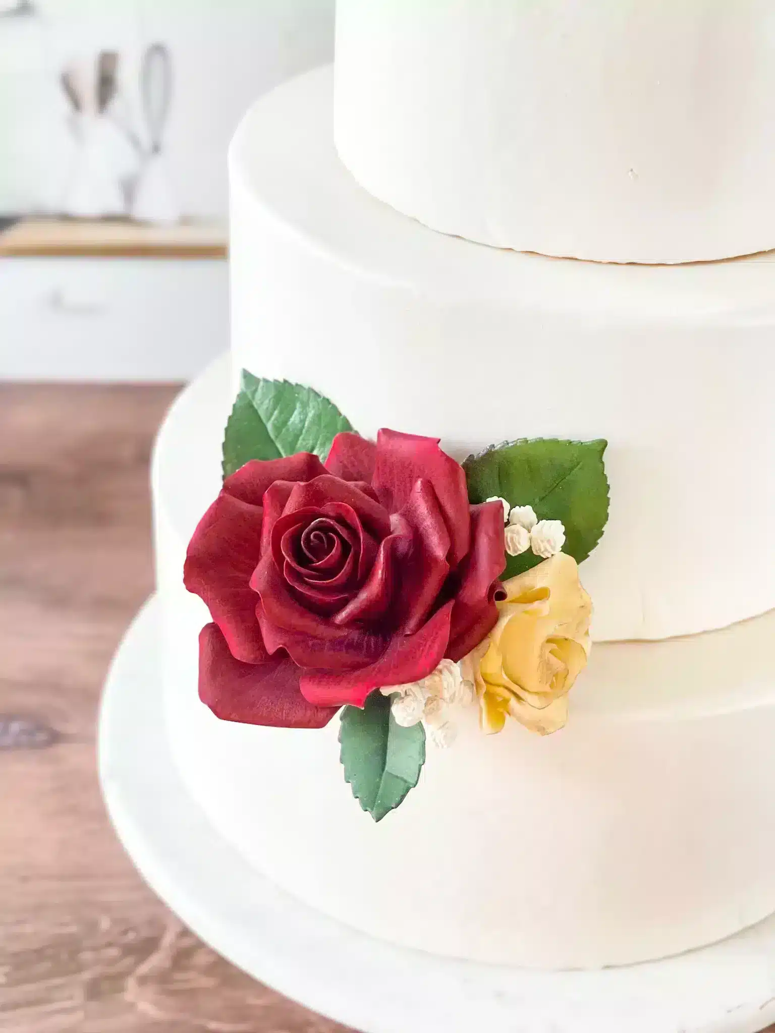 three tier cake with red rose sugar flower close up