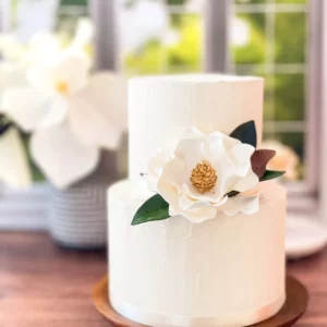 A magnolia sugar flower styled on a two tier cake