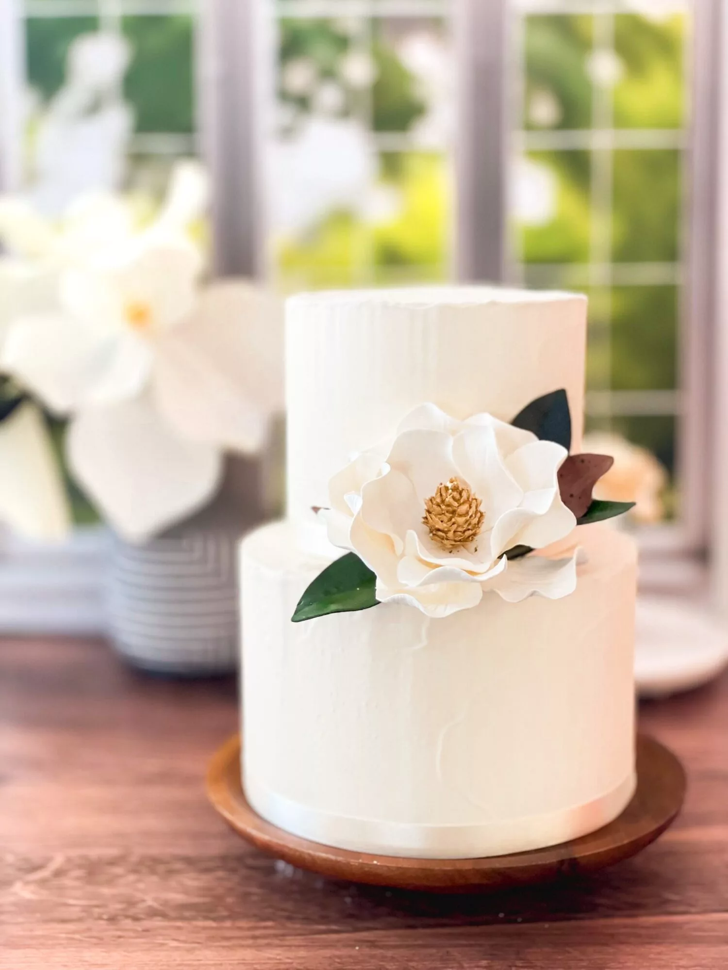 A magnolia sugar flower styled on a two tier cake