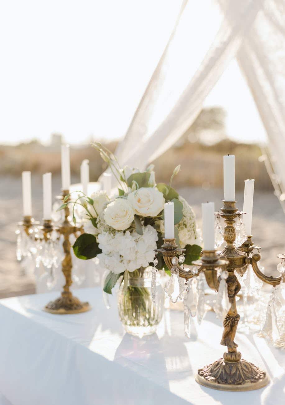 elegant candle holders and white bouquet in a vase