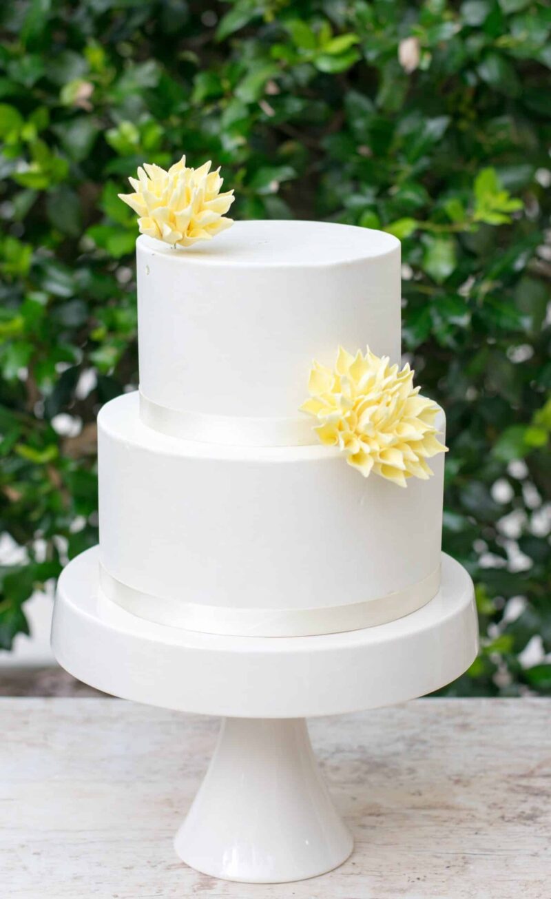 cake with two yellow dahlia sugar flowers
