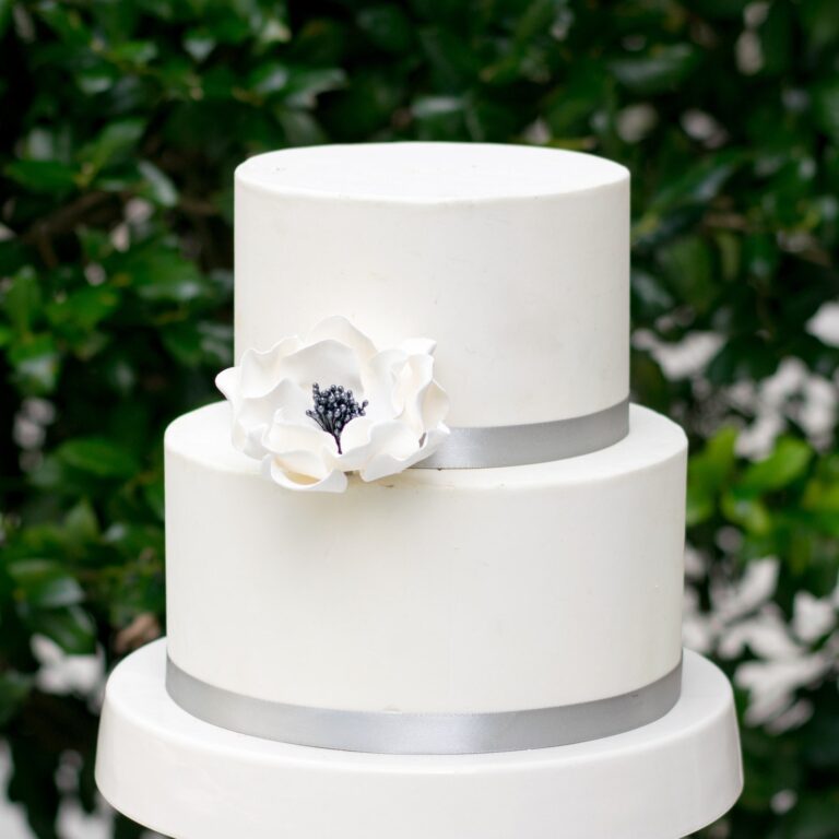 white and black medium open rose sugar flower on a two tier white fondant wedding cake