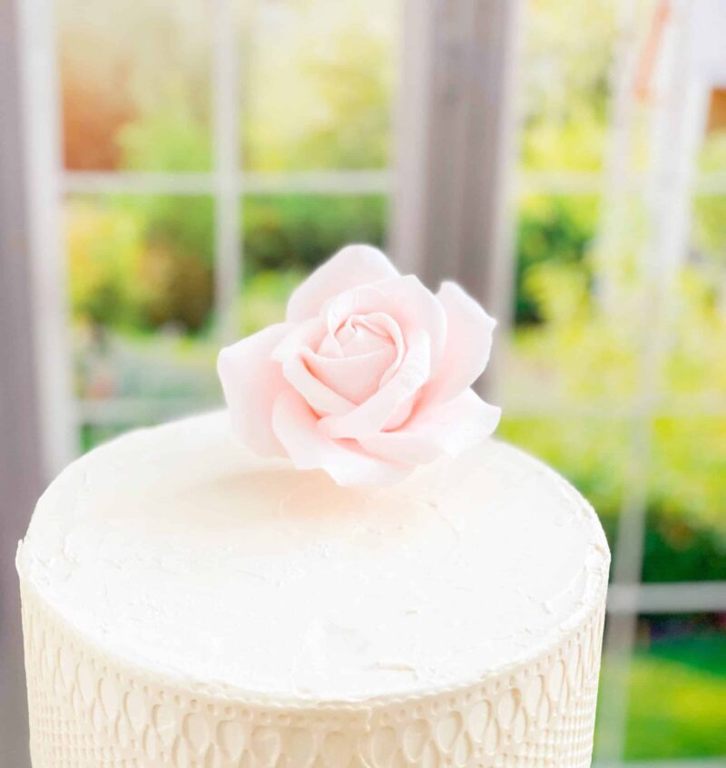 small blush rose on top of a 6" cake tier