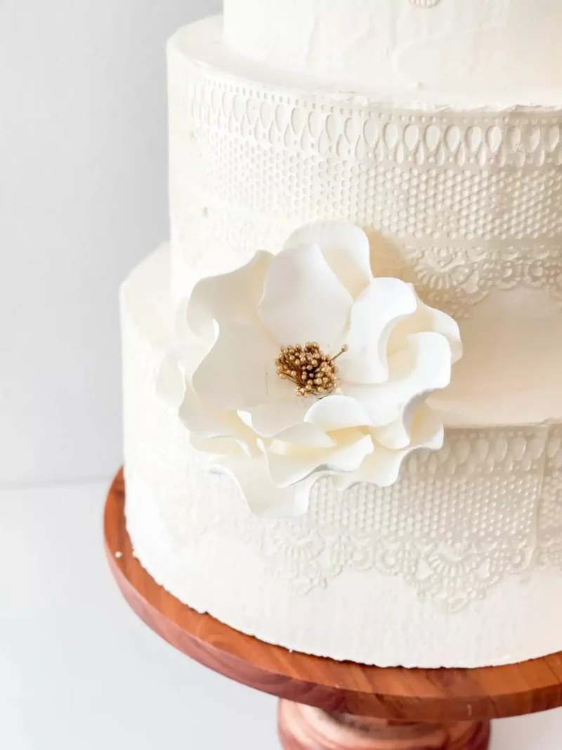 extra large white and gold open rose on a lace wedding cake
