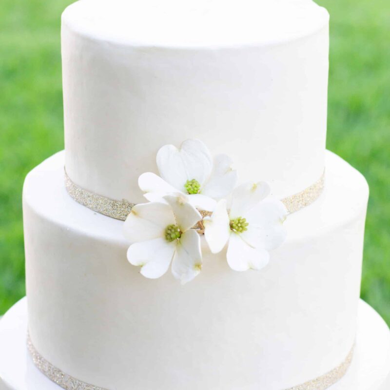 white cake with dogwood sugar flowers on top